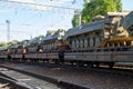 Cargo train carrying military tanks on railway flat wagons