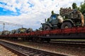 Cargo train carrying military vehicles on railway flat wagons