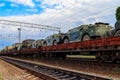 Cargo train carrying military vehicles on railway flat wagons