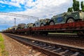 Cargo train carrying military vehicles on railway flat wagons