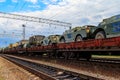 Cargo train carrying military vehicles on railway flat wagons