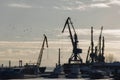 Cargo transportation industrial landscape - seaport at sunny day - cranes in harbor, silhouette Royalty Free Stock Photo