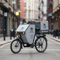 Cargo tricycle designed for delivery services stands on a city street. It features a large, Royalty Free Stock Photo