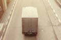 Cargo truck driving on a highway, aerial view. Back view of delivery van in motion. Dirty truck moving on the asphalt roadwith Royalty Free Stock Photo