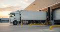 Cargo truck parked at loading dock, ready for unloading goods, surrounded by industrial warehouse environment, showcasing Royalty Free Stock Photo