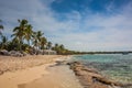 Caribbean beach with a lot of palms and white sand, Dominican Republic. Sunny warm day at the sea under palm trees. Sun loungers Royalty Free Stock Photo