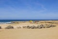 Caribbean sea coast with a yellow beach enclosed by massive rocks and an abandoned structure right at the water\'s edge. Royalty Free Stock Photo