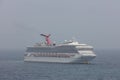 The Caribbean Sea - May 26, 2020: Aerial shot of Carnival Sunrise sailing at sea in the fog. Grey foggy sky in the background