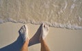 Caribbean tourist male feet on white sand shore