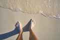 Caribbean tourist male feet on white sand shore