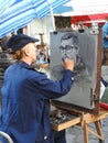 Caricaturist artist at work Place du Tertre Montmartre Paris