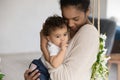 Caring African American mom cuddle baby daughter Royalty Free Stock Photo
