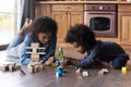 Caring African American mother and daughter playing with wooden blocks