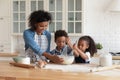 Caring African American mother with little kids cooking together