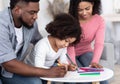 Caring African American Parents Teaching Their Little Daughter Drawing At Home