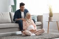 Caring arab husband making shoulder massage for pregnant muslim wife at home