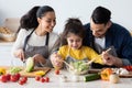 Caring Arab Parents Cooking With Their Little Daughter In Kitchen Together Royalty Free Stock Photo