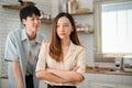 Caring Asian boyfriend is trying to comfort his angry girlfriend in the kitchen. showing care Royalty Free Stock Photo