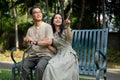 A caring Asian daughter and her father are enjoying looking at the view while relaxing in the park Royalty Free Stock Photo