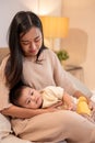 A caring Asian mom is putting her little son to sleep in her arms. napping and bedtime Royalty Free Stock Photo