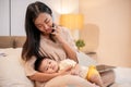 A caring Asian mom is putting her little son to sleep in her arms while she is talking on the phone Royalty Free Stock Photo