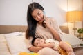 A caring Asian mom is putting her little son to sleep in her arms while she is talking on the phone Royalty Free Stock Photo