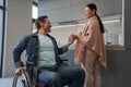 Caring Asian woman giving juice to husband on wheelchair Royalty Free Stock Photo