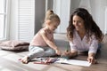 Caring babysitter drawing pictures with little cute girl Royalty Free Stock Photo