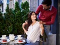 Caring bearded man putting jacket on his charming wife