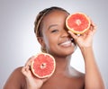 Caring for beauty thats loud and proud. Studio shot of an attractive young woman holding a sliced grapefruit against a