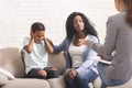 Caring black mother comforting her naughty little daughter at psychologist consultation