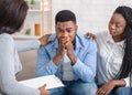 Caring black wife and counselor supporting man during psychotherapy session Royalty Free Stock Photo
