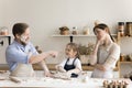 Caring bored mom watching happy toddler kid and dad baking Royalty Free Stock Photo