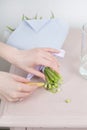 Caring for a bouquet of flowers, step by step. Cut the stems and put in a vase. Young woman holding a beautiful bunch of Royalty Free Stock Photo