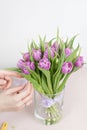 Caring for a bouquet of flowers, step by step. Cut the stems and put in a vase. Young woman holding a beautiful bunch of Royalty Free Stock Photo