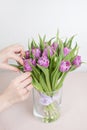 Caring for a bouquet of flowers, step by step. Cut the stems and put in a vase. Young woman holding a beautiful bunch of Royalty Free Stock Photo