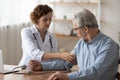 Caucasian male doctor measure blood pressure of mature patient Royalty Free Stock Photo