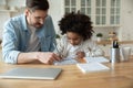 Caucasian stepfather helps with homework little mixed-race daughter