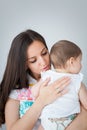 Loving mother is calming her baby by tapping and massaging its back