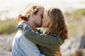 Caring, couple and kissing or hug on mountain, nature and scenery with passionate people in relationship. Love, care and