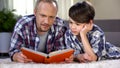 Caring dad helping his schoolboy to understand difficult subject, homework