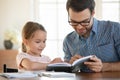 Caring dad teach small preschooler daughter reading
