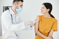 caring doctor in protective gloves to stick the injection to a woman covid vaccination Royalty Free Stock Photo