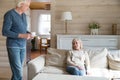 Caring elderly husband bring hot drink to beloved wife