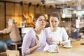 Empathetic woman comforting upset younger sister in cafe