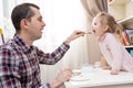 Caring father feeding his beloved daughter delicious food with a spoon. Royalty Free Stock Photo