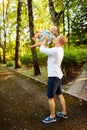 Caring father play with little daughter at the park, handsome man lift in air lovely baby girl, daddy tender looking at