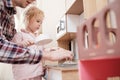 Caring father plays with his cute daughter in a small children kitchen, in a cozy home. Lifestyle. Royalty Free Stock Photo