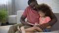 Caring father reading fairy tales aloud to his little daughter, family love Royalty Free Stock Photo