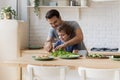 Caring father teach little son chopping vegetables